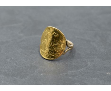 A gold half sovereign ring dated 1902 with attached yellow metal loop, bearing marks, size N and approx 5.5g  (wear to coin)