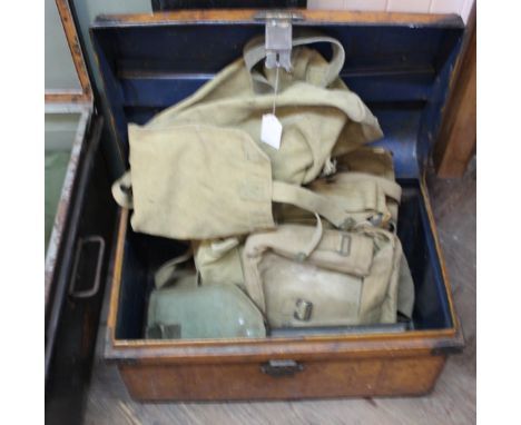 A small tin trunk containing various military canvas bags etc (some WWII dated) with an entrenching tool