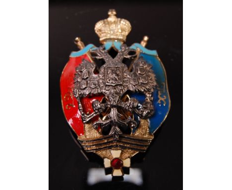 A Russian Caucasian Native Equestrian Division enamelled badge depicting the Russian state emblem under the golden Imperial C
