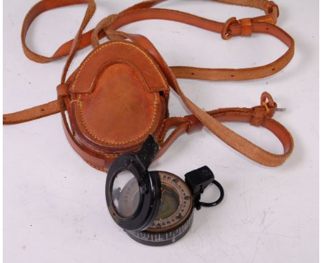 A WW II Mk III brass cased military compass, stamped T.G. & Co Ltd, London NoB 234569 and dated 1943, in a stitched brown lea