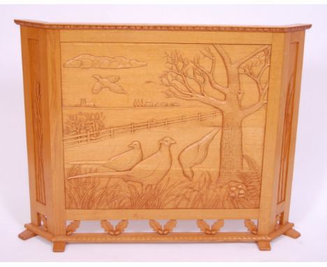 A light oak fire screen, the front panel carved with pheasants amongst a landscape, w.110cm.