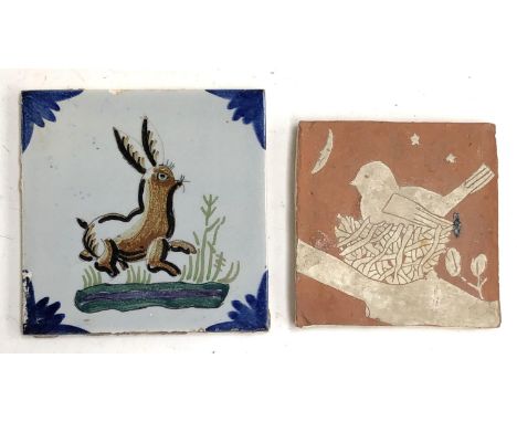 A delft tile painted with a hare 14cm square, together with a studio pottery tile depicting a bird in a nest with the moon in