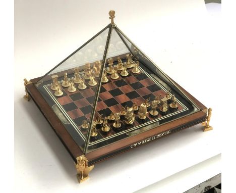 A Franklin Mint 'Treasures of Tutankhamun' gold plated and enamelled chess set within a glass pyramid 