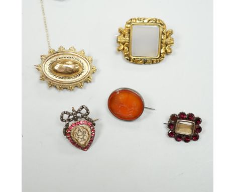 Five assorted antique brooches, comprising an early 19th century foiled ruby and hair work heart shaped brooch, 2.25cm, an ea
