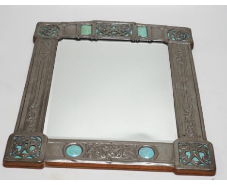 A Miller Brothers Art Nouveau embossed pewter mirror with cabochon turquoise enamel bosses, 48cm high x 39cm wide