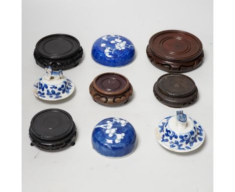 A group of Chinese wooden stands and ceramic lids