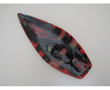 A Poole Pottery spear form Delphis dish by Jean Millership, red ground with black, green, blue and yellow, 44cm x 17.5cm