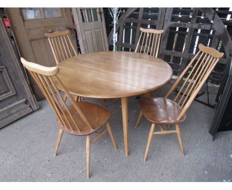 An Ercol light elm drop leaf dining table and four stick high backed dining chairs