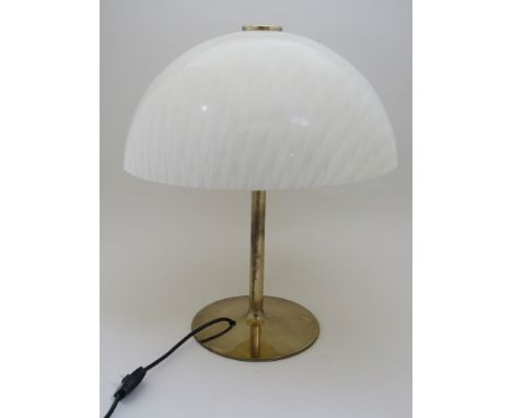 A brass coloured metal desk lamp with patterned lucite shade 