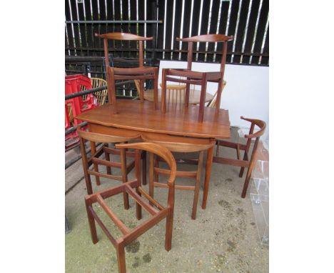 An Afrormosia dining table with six chairs with cow horn back rail. No seat pads.