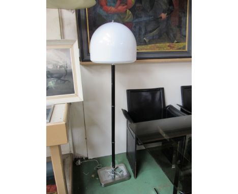A standard lamp with painted black sectional stem and opaque white shade 
