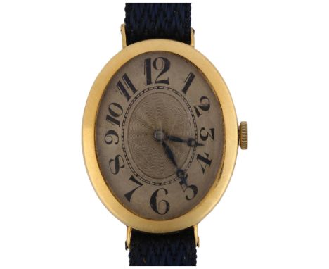 An Art Deco 18ct gold mechanical wristwatch, oval silvered dial with engine turned decoration, hand painted Arabic numerals a