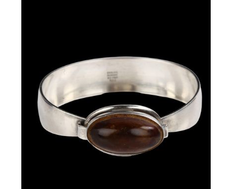 NIELS ERIK FROM - a Danish modernist sterling silver and amber torque bangle, set with oval cabochon amber, setting height 18