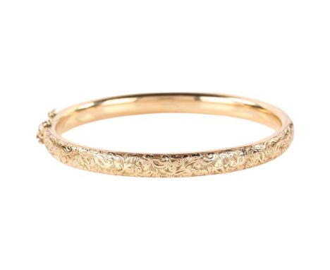 An early 20th century 9ct rose gold hinged bangle, engraved foliate decoration, band width 6.3mm, internal circumference 17cm
