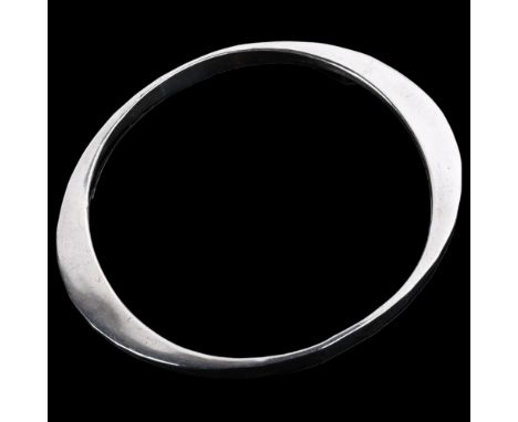 TONE VIGELAND - a heavy Norwegian sterling silver slave bangle, plain asymmetrical form with planished decoration, band width