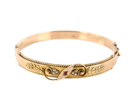 An Edwardian 9ct rose gold ruby and pearl hinged bangle, with floral motif and rope twist border, maker's marks JGG, hallmark