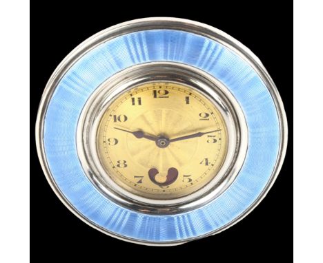 An Art Deco French silver and blue enamel boudoir clock, with gilded dial, Arabic numerals and engine turned decoration, over