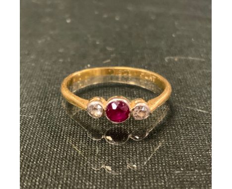 A diamond and ruby ring, central round cut red ruby, flanked by smaller diamond accented shoulders, 18ct gold shank, size O, 