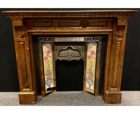 Architectural salvage - a Victorian cast iron fire surround, tile inset, with oak chimney piece, 116.5cm tall x 137.5cm wide.
