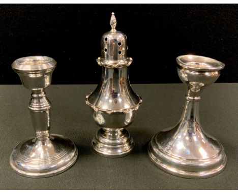 A silver boudoir candlestick, 10.5cm high, Birmingham 1924;  another, 10.5cm high, Birmingham 1965;  a silver pepper caster, 