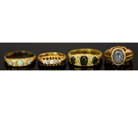 Four 18ct Gold Gem Set Rings, one set with three green stones, size P, one set with light blue stone, size E, one set with fo