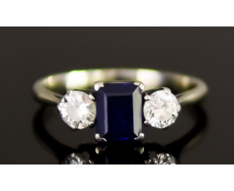 An 18ct White Gold Three Stone Sapphire and Diamond Ring, 20th Century, set with a centre faceted sapphire, approximately .75