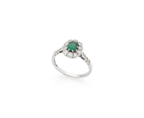 An emerald and diamond cluster ring Claw-set with a cut-cornered rectangular-cut emerald, weighing approximately 0.55cts, in 