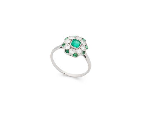 An emerald and diamond cluster ring Millegrain-set with a cut-cornered rectangular step-cut emerald, in a border of round-cut