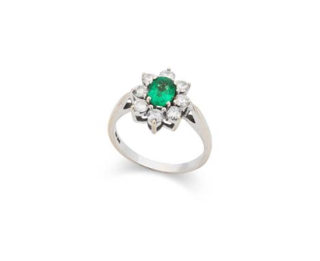 An emerald and diamond cluster ring Claw-set with an oval-cut emerald, weighing approximately 0.66cts, in a border of round b