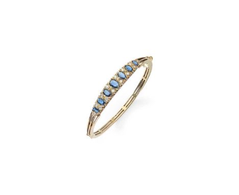 A sapphire and diamond bangle Of hinged design, set with graduated oval-cut sapphires between pairs of small round brilliant-