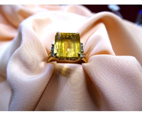 An unmarked Engagement ring with large square cut yellow stone (tourmaline ?), with three diamond chips set to both sides, st