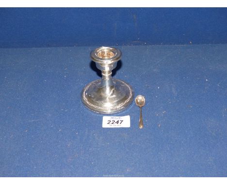 A Silver candlestick, Chester 1924, [some dents] together with a Silver salt spoon.