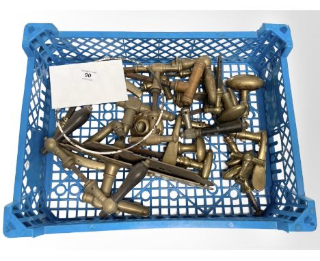 A crate of vintage brass door handles and others.