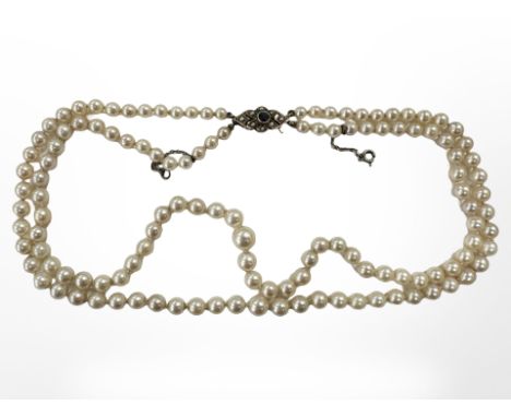 A good quality double strand of graduated pearls with 9ct yellow gold clasp mounted with split pearls and blue sapphire, with