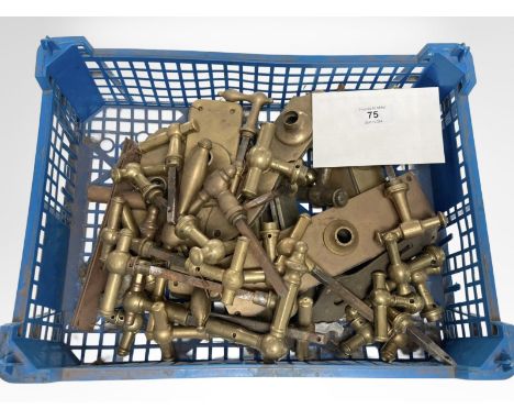 A crate of vintage brass door handles and door plates.