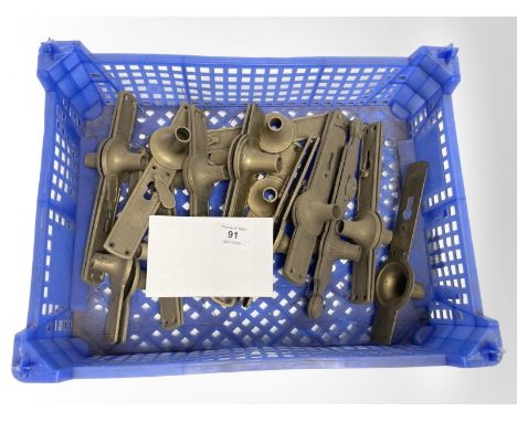 A crate of vintage brass door plates and handle collars.