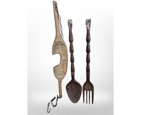A 19th-century wooden yoke, together with a large carved fork and a spoon, length 90cm.