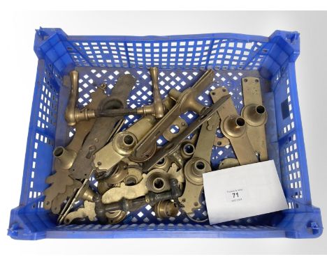 A crate of vintage brass door plates and door handles.