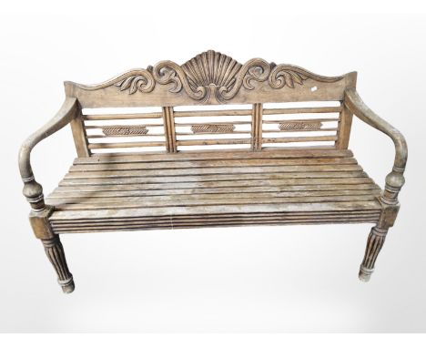 A carved teak garden bench, width 134 cm 