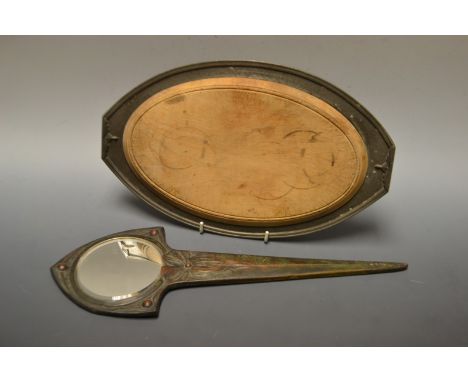 A Period Pewter hammered oval stand and  bread board, geometrical handles, 34cm wide, shape no.644;  an Art Nouveau bronzed d