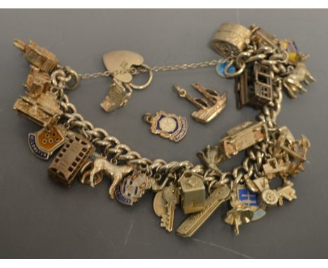 Jewellery - a silver charm bracelet, suspending twenty seven charms including Bus, Church, London Taxi. Car, Cine camera, Whi