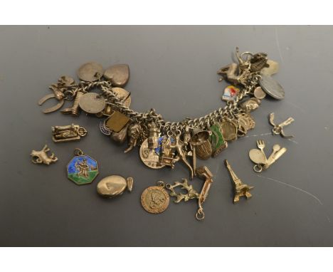 Jewellery - a silver charm bracelet, suspending approx forty five silver and white metal charms including Head, Boot, Salaman