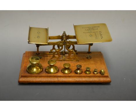 A pair of late 19th century brass postage scales, 1oz-12oz, warranted correct, with seven graduated weights, 8oz to 1/4oz, wo