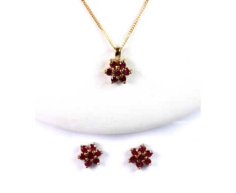 A pair of 9ct yellow gold (stamped 375) ruby set flower shaped stud earrings and matching pendant and chain.