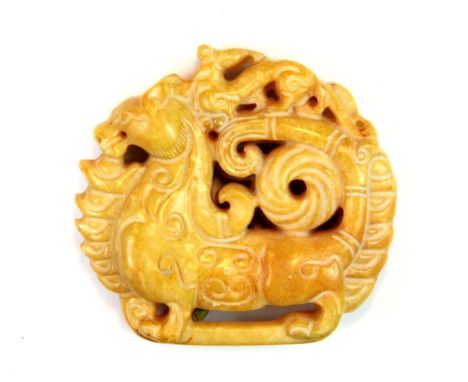 A carved Chinese yellow jade amulet of a phoenix riding a dragon, W. 5cm.