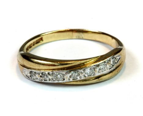 A 9ct yellow and white gold diamond set crossover ring (R).