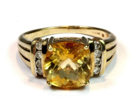 A 9ct yellow gold ring set with a faceted cushion cut citrine and diamond set shoulders (S).