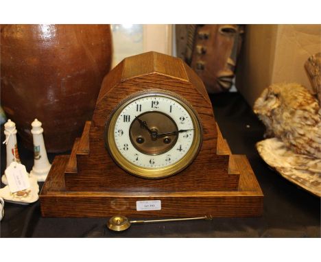 Early 20th Century oak cased mantel clock, with an angled body, twin tain