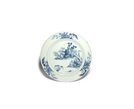 A large delftware charger, c.1760, probably Dublin, painted in blue with a pagoda beside rockwork, pine trees and bamboo in a