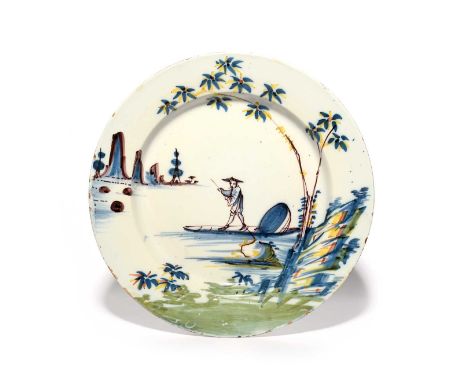 A Bristol delftware charger, c.1730, painted in blue, manganese, green, yellow and red with a Chinese figure punting a sampan